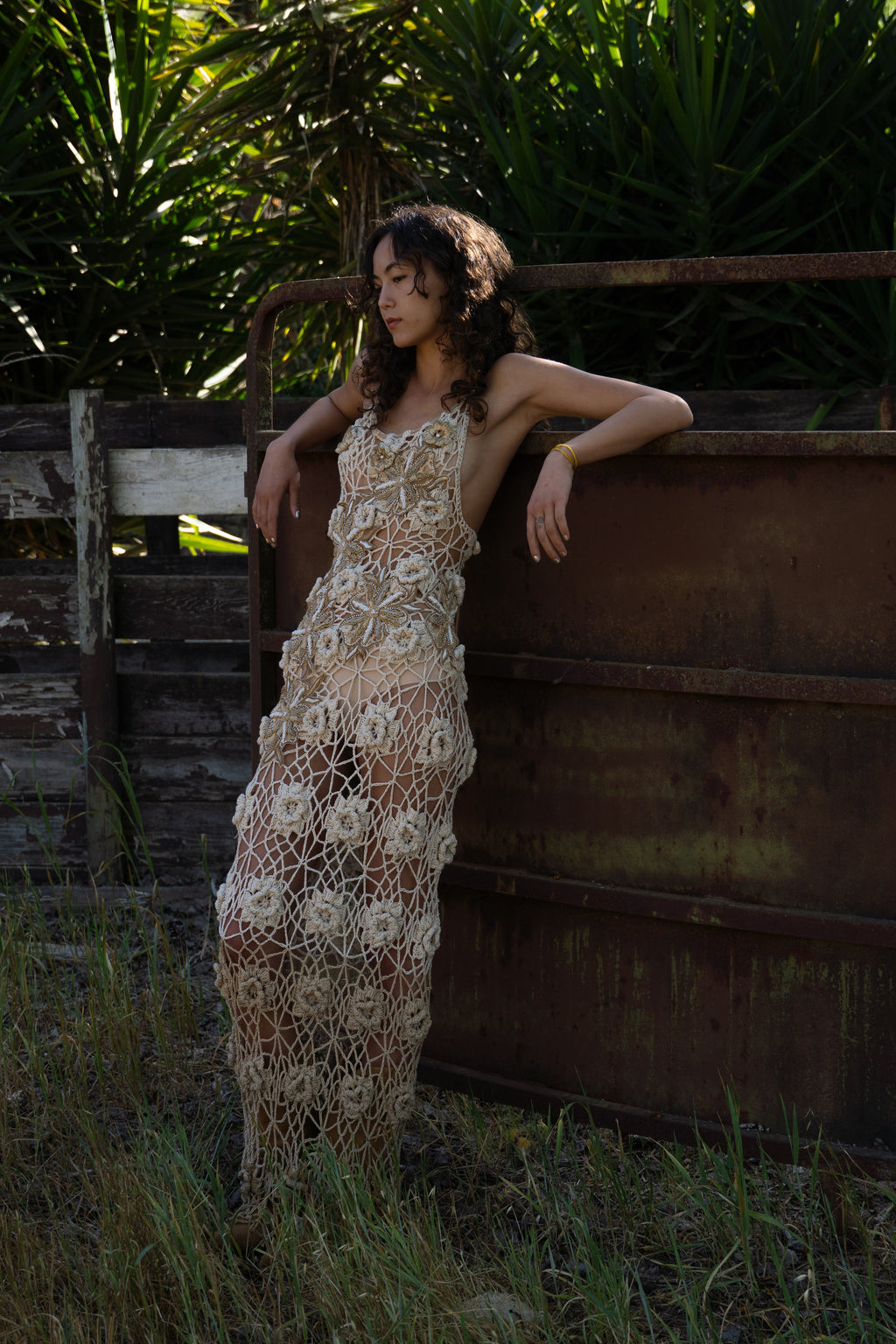 La Sirena hand-crocheted maxi dress with 3D floral embellishments in honey, gold, and cream tones, low back design
