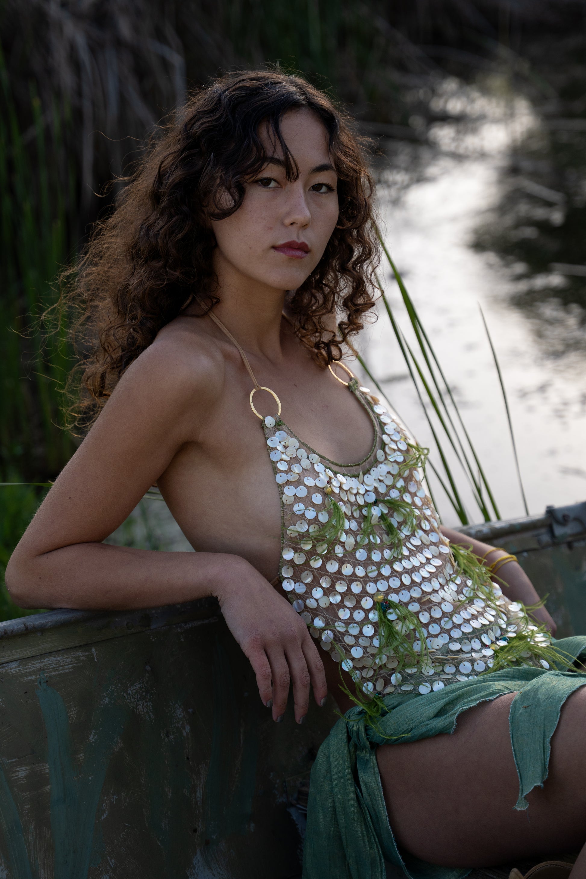Aura handmade halter top with natural abalone seashell embellishments, sheer nude tulle, light olive ostrich feathers and red and green crystal accents
