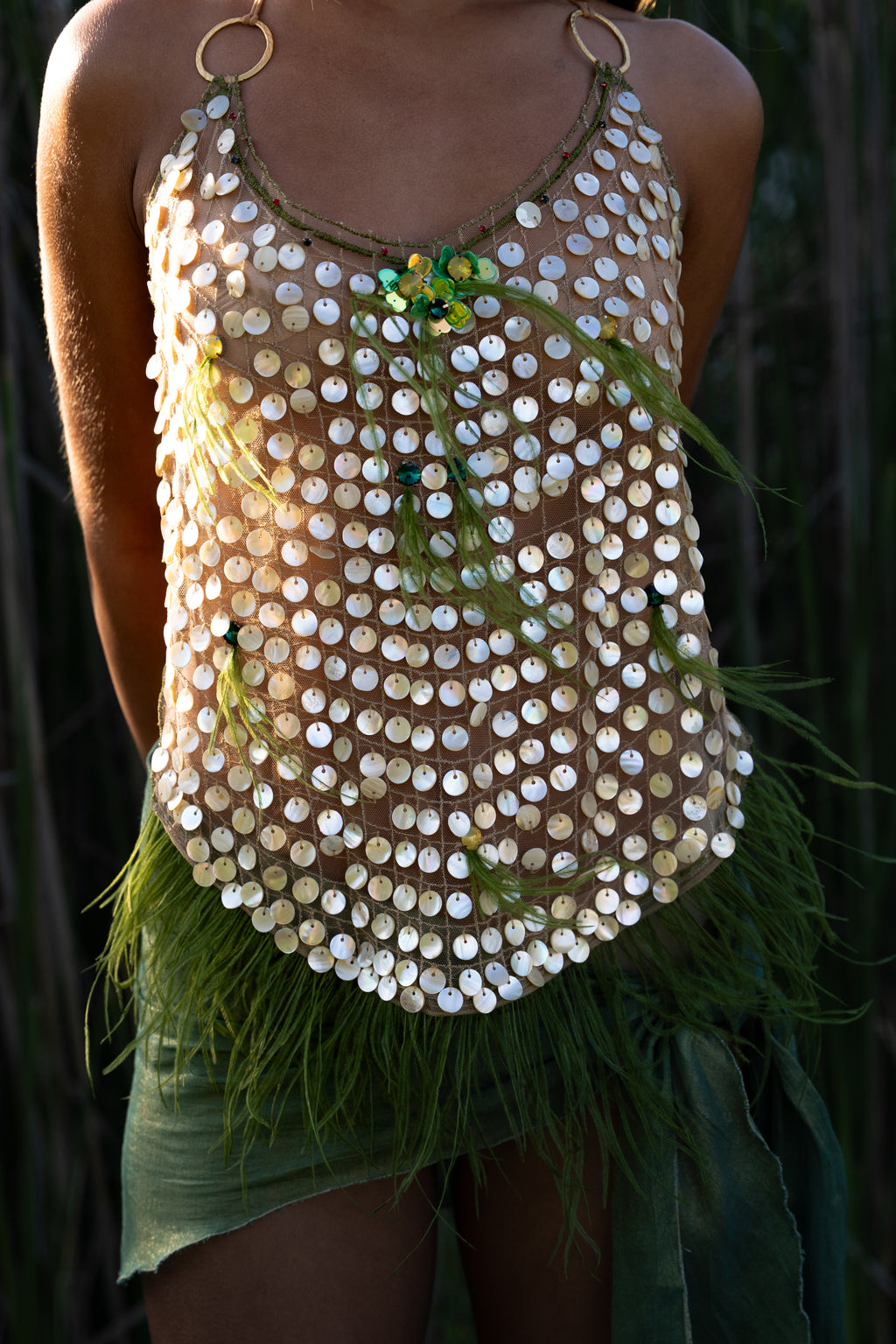 Aura handmade halter top with natural abalone seashell embellishments, sheer nude tulle, light olive ostrich feathers and red and green crystal accents
